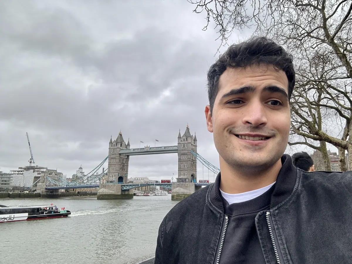 Subash with Tower Bridge and the Thames behind him in London