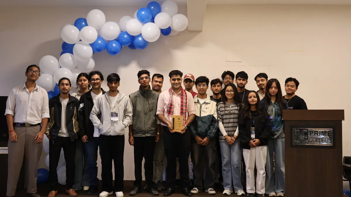 Subash with bachelor's students at Prime College after the talk, holding a wooden plaque